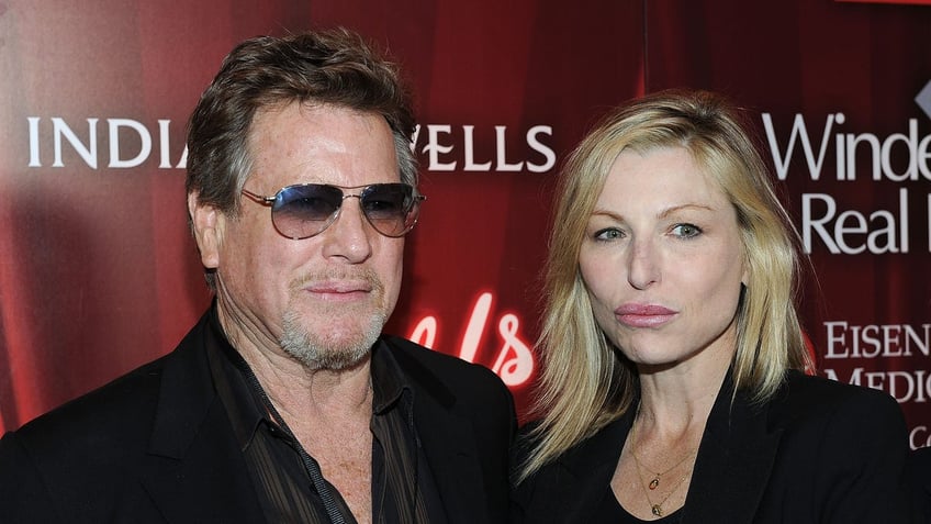 Ryan O'Neal wearing sunglasses posing with Tatum O'Neal