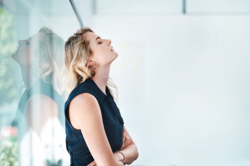 Shot of a young businesswoman looking stressed out in an office