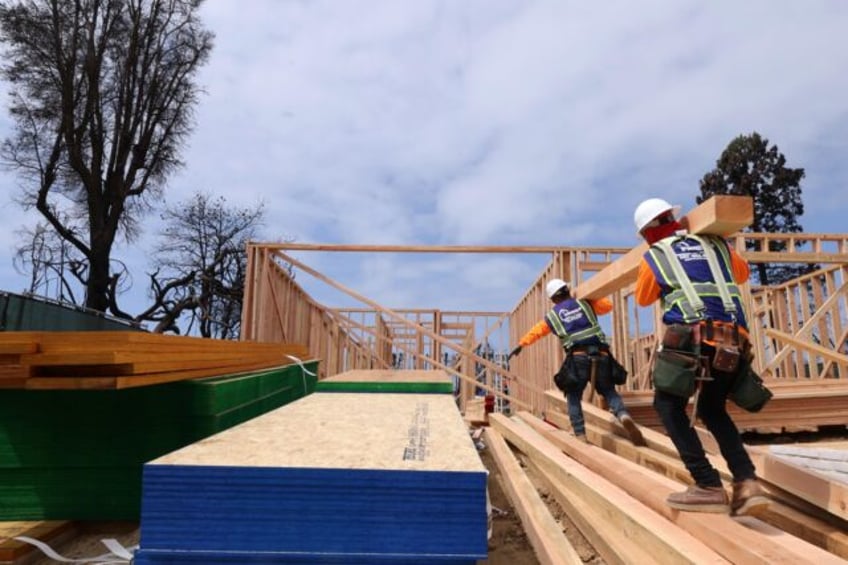 PALISADES, CA  - APRIL 24,  2025 - - Workers carry lumber while helping to construct the