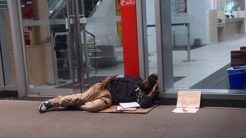 homeless person on sidewalk lying