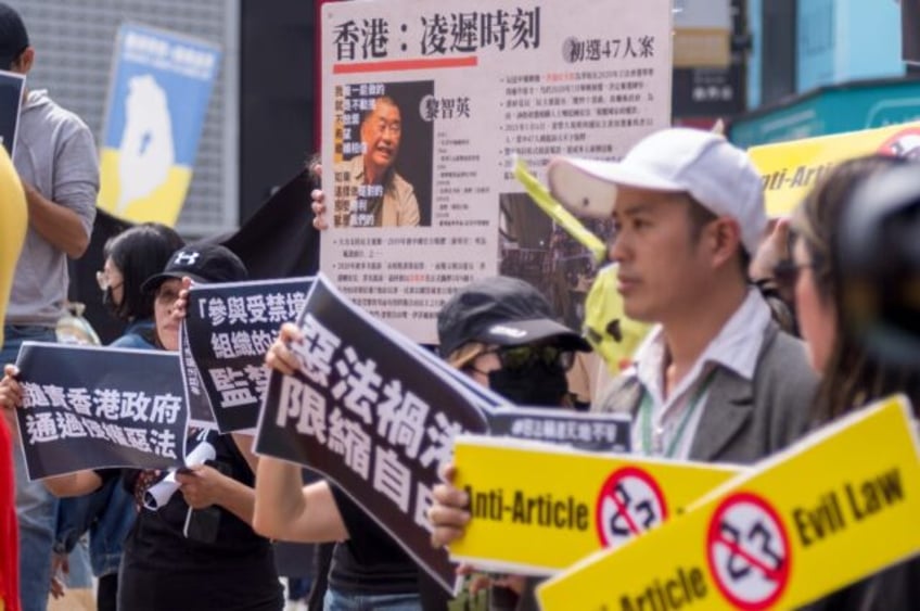 Hong Kong people living in Taiwan display placards and a poster showing detained pro-democ