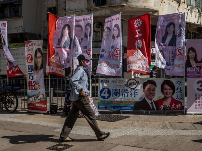 A man walks past signs for candidates during the district council election in Hong Kong on December 10, 2023. (Photo by ISAAC LAWRENCE / AFP) (Photo by ISAAC LAWRENCE/AFP via Getty Images)