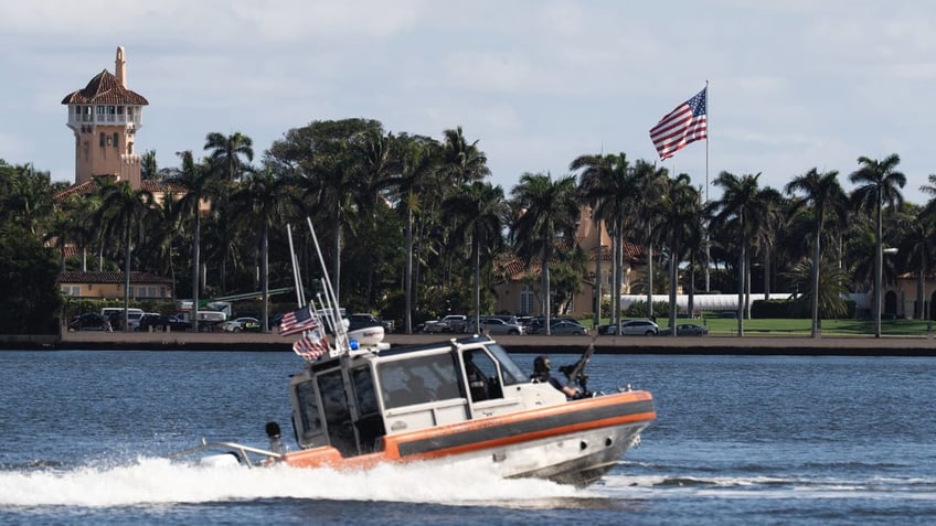 The U.S. flag is shown at the Mar-a-Lago compound in Palm Beach, Florida, while a U.S. Coast Guard boat patrols around the vicinity, Monday, Jan. 13, 2025. U.S. flags at President-elect Donald Trump's private Mar-a-Lago club are back to flying at full height.