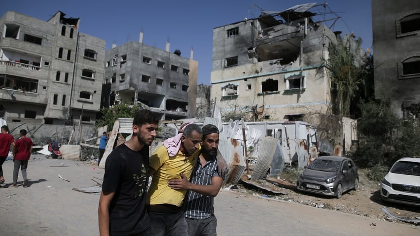 Palestinians help a wounded man after Israeli strikes in Nuseirat refugee camp, Gaza Strip, on June 8, 2024. The U.N. human rights office is citing possible war crimes by Israeli forces and Palestinian armed groups in connection with a deadly raid by Israeli forces that freed four hostages over the weekend. Office spokesman Jeremy Laurence expressed concerns about possible violations of rules of proportionality, distinction and precaution by the Israeli forces in Saturday’s raid at the urban Nuseirat refugee camp.