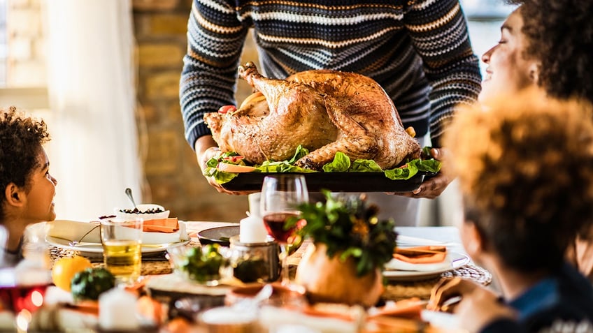 Father presents Thanksgiving turkey to family