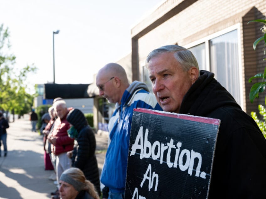 A pro-life demonstrator stands in front of EMW Women's Surgical Center, an abortion c
