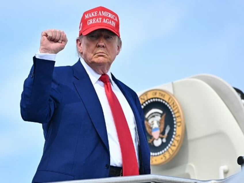 US President Donald Trump pumps his fist as he boards Air Force One at Morristown Municipa