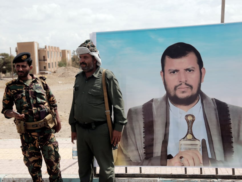 SANA'A, YEMEN - MARCH 9: Yemen's Houthi fighters stand next to a billboard depicting the picture of the Houthi leader Abdul Malik Al-Houthi as they guard during a rally and parade against the U.S.-led aerial attacks on Yemen and in solidarity with Palestinians against the Israeli war on March 9, 2024, in Sana'a, Yemen. (Photo by Mohammed Hamoud/Getty Images)