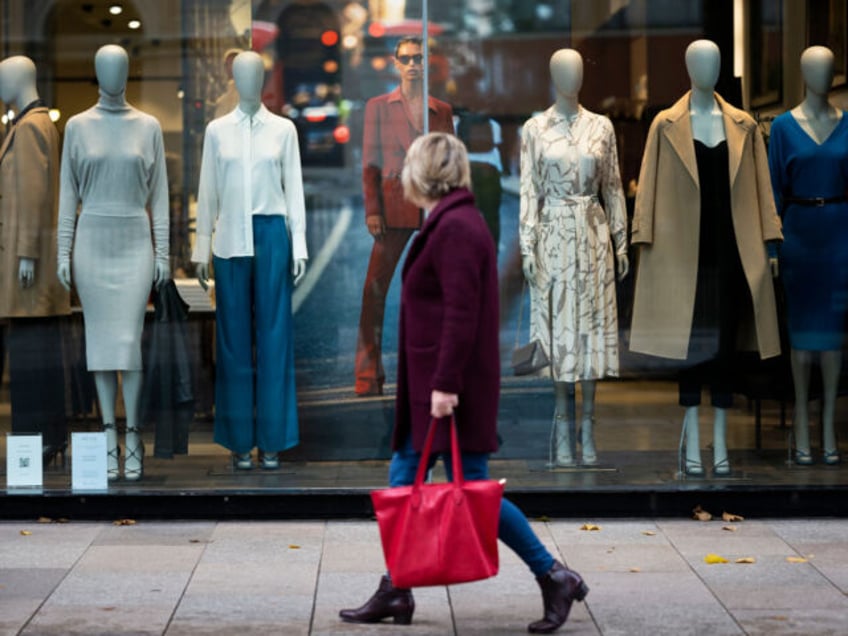 CARDIFF, WALES - OCTOBER 21: A woman walks past mannequins in a Reiss store on October 21, 2022 in Cardiff, United Kingdom. The Office For National Statistics announced that September's retail sales volumes have fallen by 1.4% much more than expected as households cut back spending in the face of …