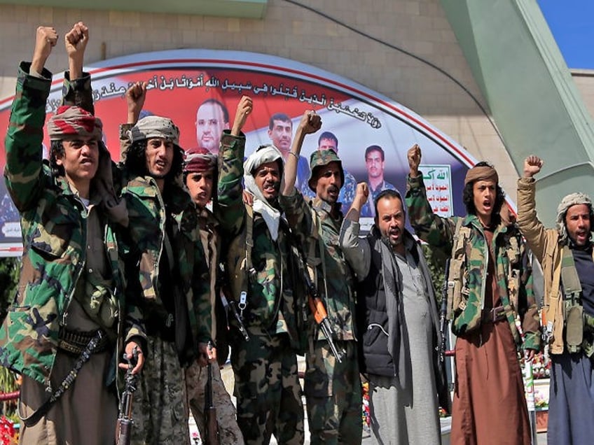 Fighters loyal to Yemen's Houthi rebels raise their fists and chant slogans as they visit the grave of slain Huthi political leader Saleh al-Sammad at al-Sabeen square in the capital Sanaa, on January 11, 2021. - In April 2018, al-Sammad, who was on the Saudi-led coalition's wanted list, was killed …