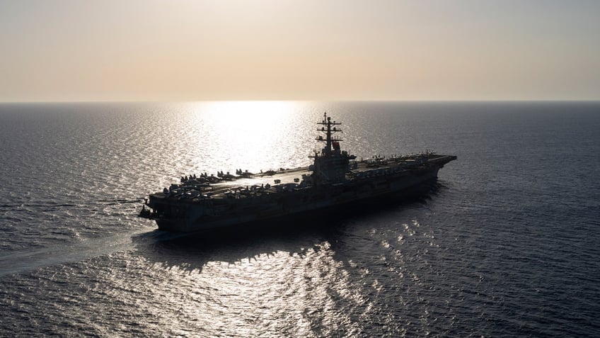 The USS aircraft carrier Dwight D. Eisenhower sails in the Red Sea as the sun reflects off the water.