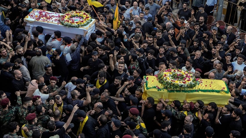 Mourners carry the coffins