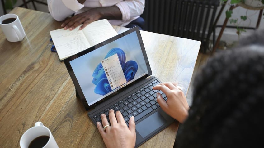 A woman using Microsoft 365 on her laptop.