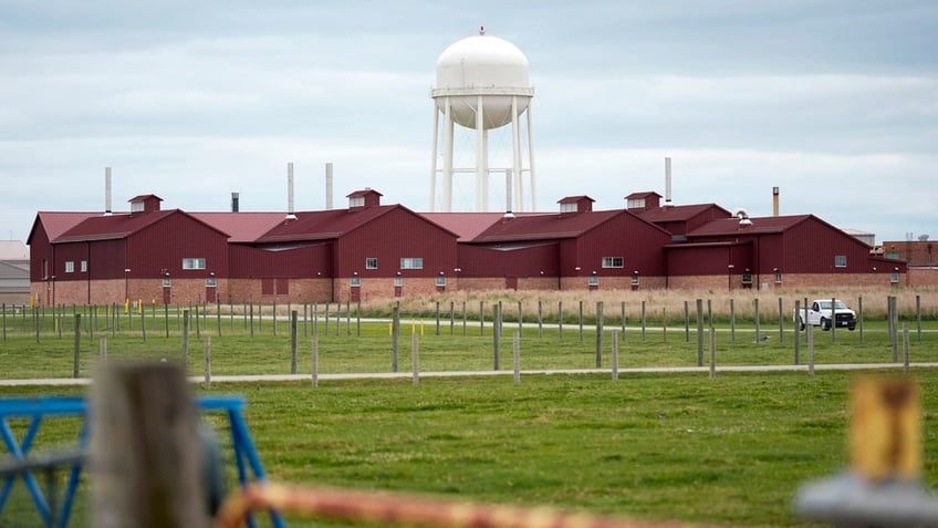 A white water tower stands over the red animal containment facility on the campus of the U.S. Department of Agriculture's National Animal Disease Center research facility.