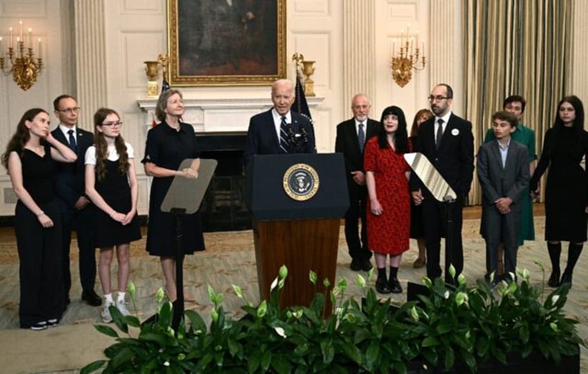 US President Joe Biden, standing alongside family members of the freed prisoners, speaks a