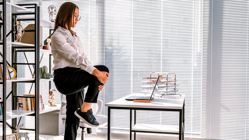 Woman stretching while working at office