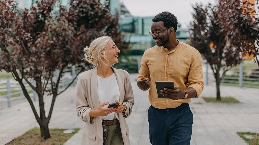 two coworkers on a walk outside office