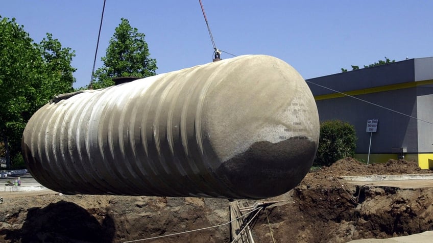 Workers remove a 10,000-gallon underground gasoline storage tank to be replaced with a new tank at a gas station in Sacramento, California.