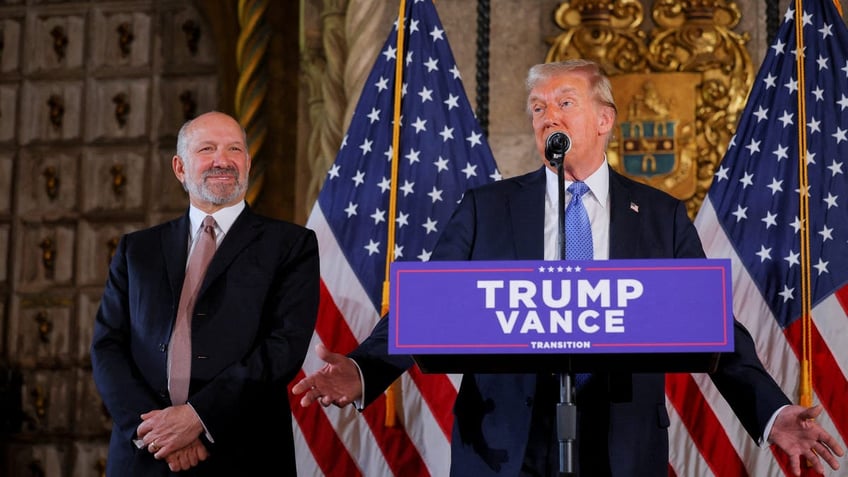 President Trump at lectern, Howard Lutnick to his right