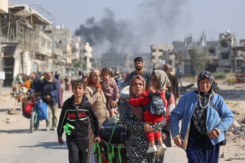 Palestinians displaced from shelters in Beit Hanoun cross the main Salaheddine road into J