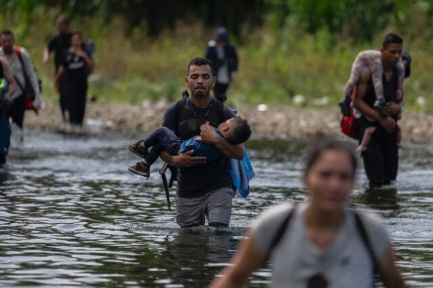 Migrants cross the Tuquesa river near Bajo Chiquito village, the first border control of t