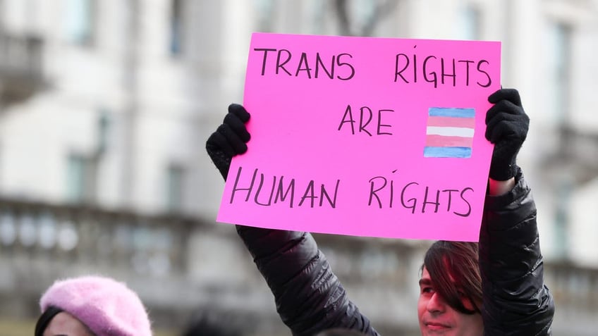 A protester holds a placard outside of the Pennsylvania Capitol this week during a 50501 Movement protesting the Trump administration's policies aimed at transgender folks.