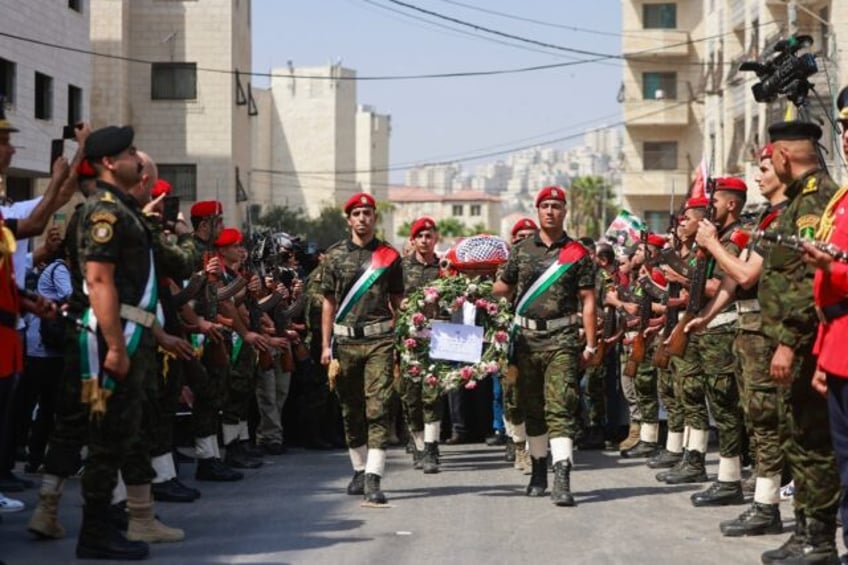 Palestinian security forces carry the body of slain Turkish-American activist Aysenur Ezgi