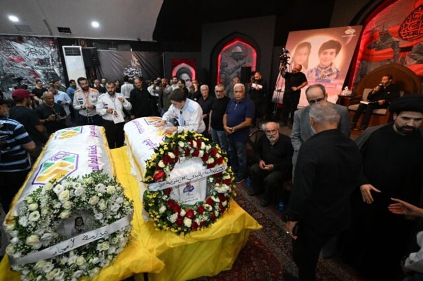 People gather around the coffins of two children, Hassan and Amira Muhammed Fadallah, duri