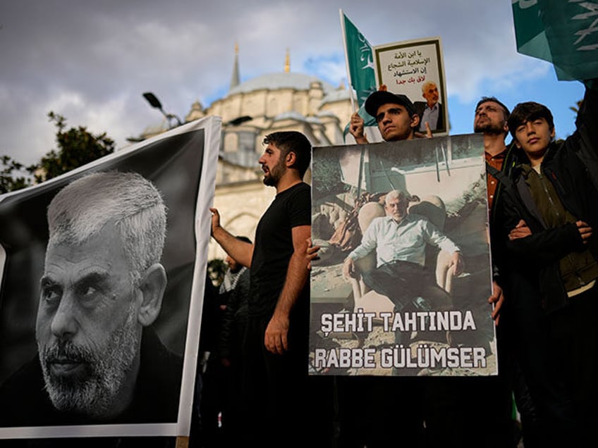 People hold posters and a banner with photographs of Hamas leader Yahya Sinwar, who was ki