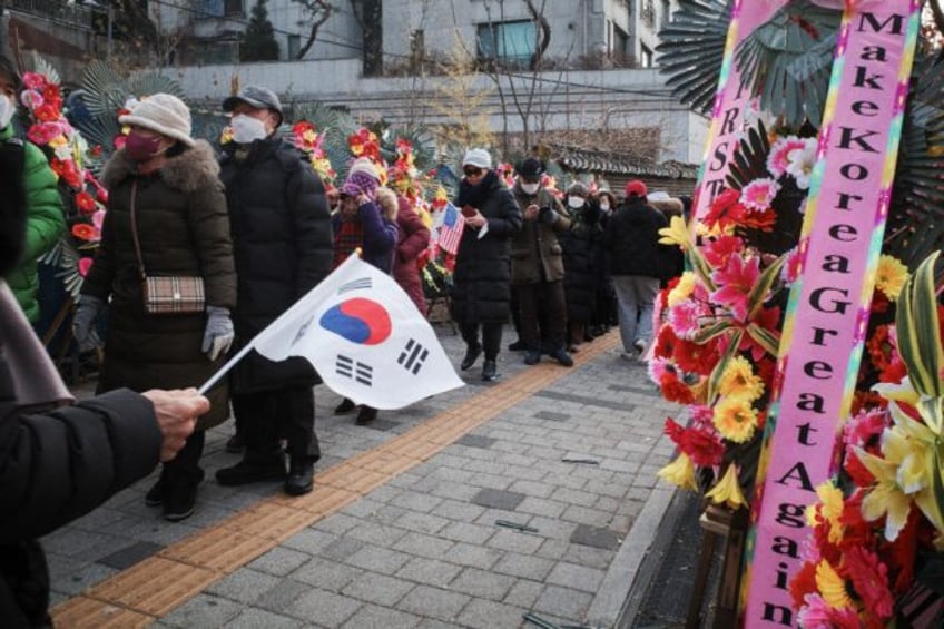 Supporters of impeached South Korean president Yoon Suk Yeol queue up for food beyond flow