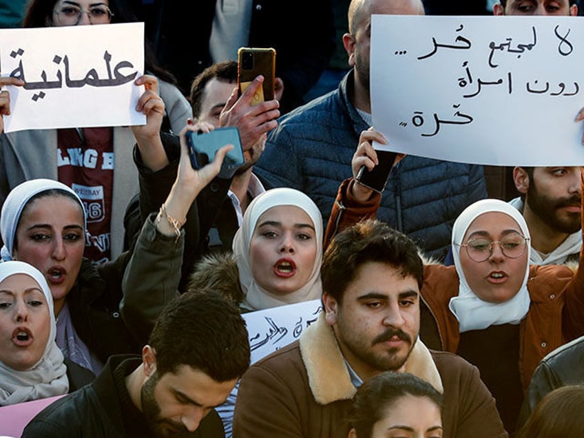 Syrian women chant slogans as they hold placards with Arabic that read: "No for free socie