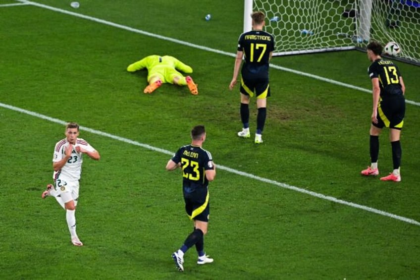 Kevin Csoboth (L) sprints past dejected Scotland players after scoring Hungary's winner in