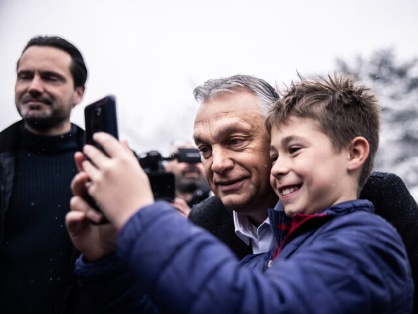 Viktor Orban, Hungary's prime minister, takes a selfie photograph with a boy, after voting