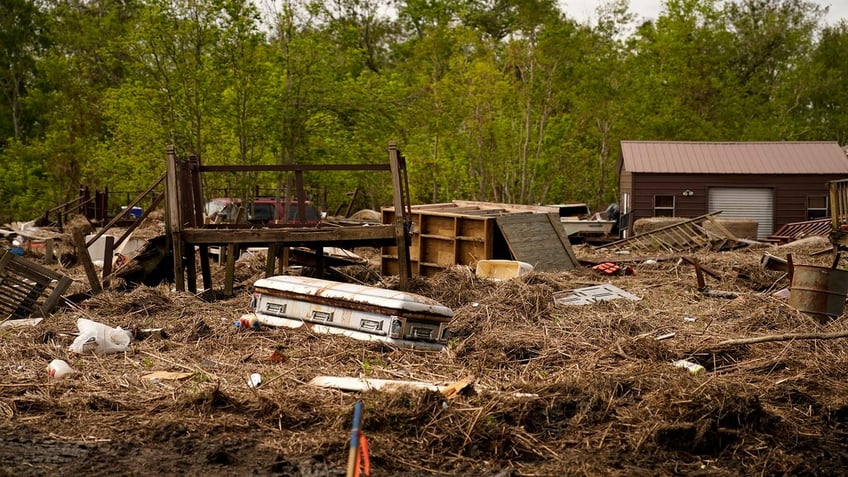 A displaced casket that floated from a cemetery during flooding from Hurricane Ida, sits among displaced marsh grass and ruin, in Ironton, La., on Sept. 27. Graves said Hurricane Ida disaster claims are still being processed.