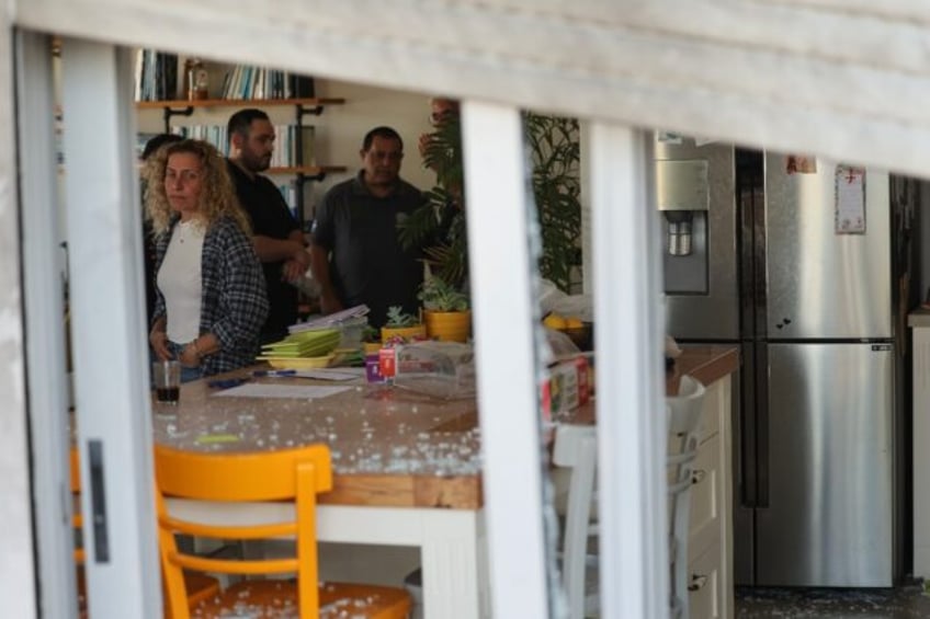 Israelis check the damage to their top-floor apartment in a residential building in centra