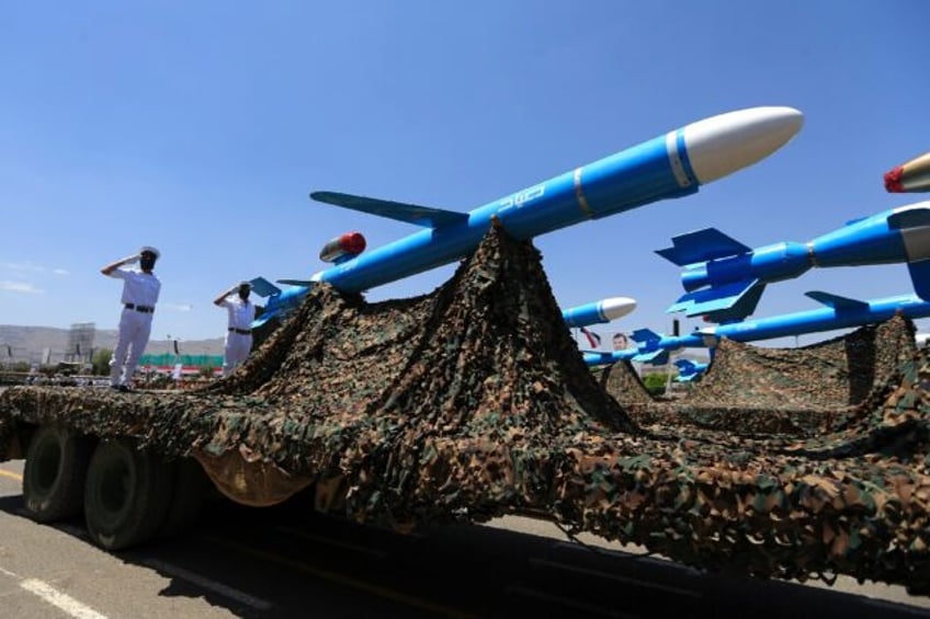 Huthi soldiers stand guard on a missile carrier during a military parade in September 2023