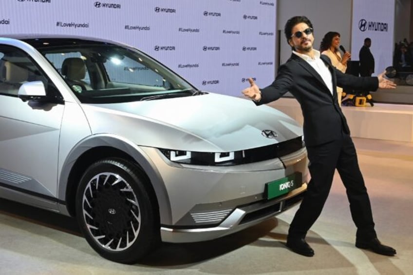 Bollywood actor Shahrukh Khan poses in front of the newly launched Hyundai IONIQ 5 during