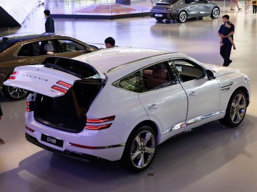 Customers look at a Hyundai Motor Co. Genesis GV 80 sport utility vehicle (SUV) at the com