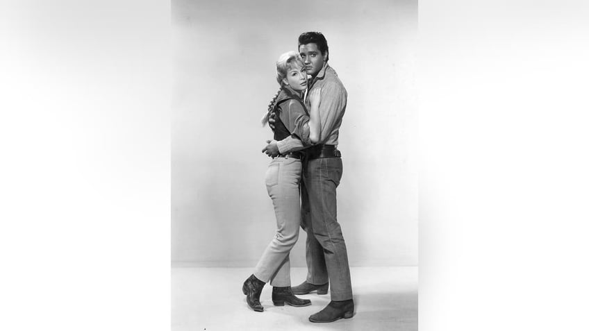 Elvis Presley embracing Barbara Eden.