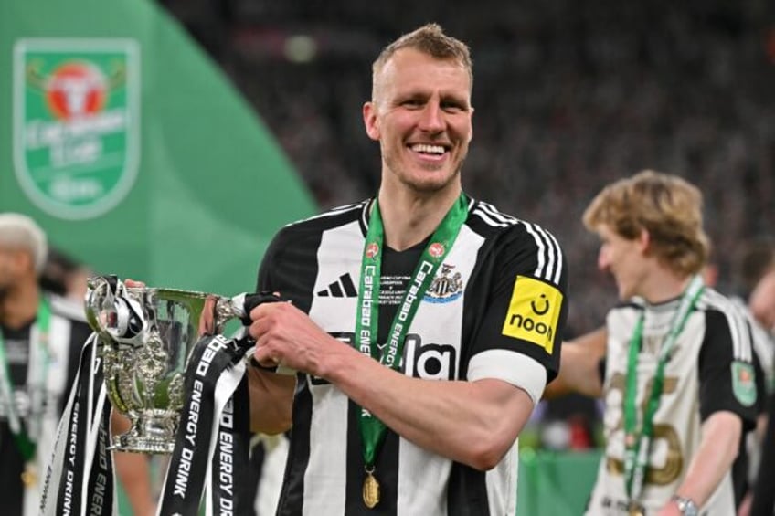 Newcastle defender Dan Burn celebrates with the League Cup trophy