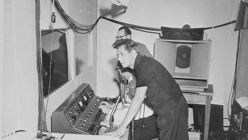 Desi Arnaz wearing all black working behind the scenes.