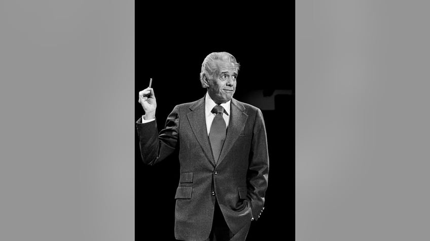 Desi Arnaz wearing a suit and holding a cigarette.
