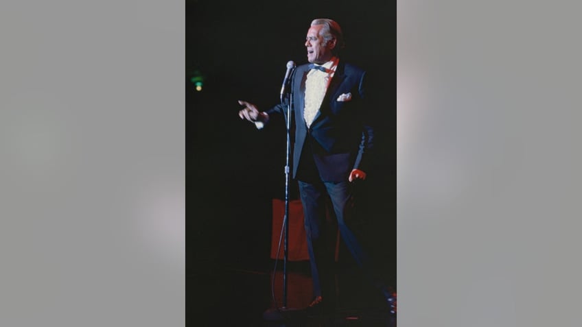 Desi Arnaz performing on stage in a suit.