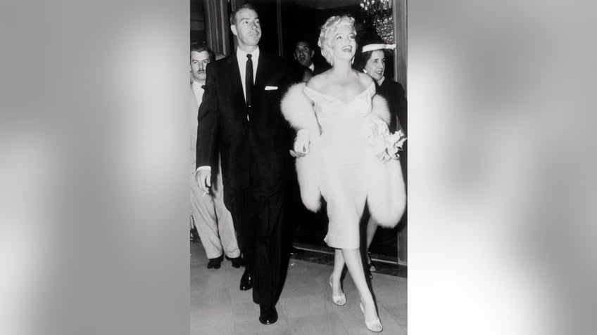 Marilyn Monroe and Joe DiMaggio walking together and looking glamorous