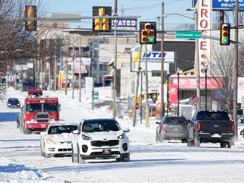 Traffic makes its way along 8th Ave. Tuesday, Jan. 16, 2024, in Nashville, Tenn. A snowstorm blanketed the area with up to eight inches of snow and frigid temperatures. (AP Photo/George Walker IV)