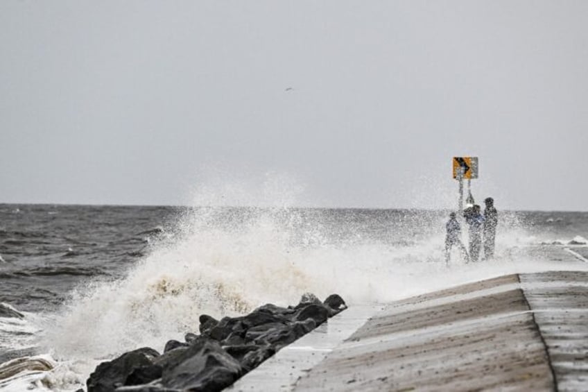 People stand on the shoreline ahead of the arrival of Hurricane Helene in Alligator Point,