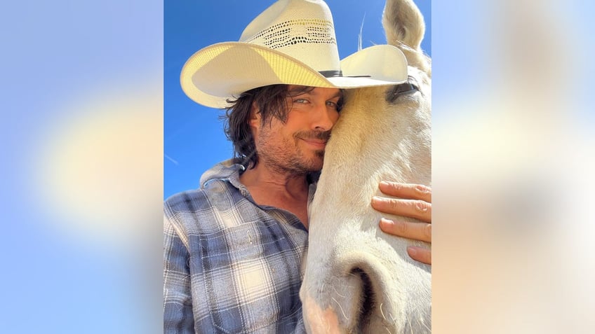 Ian Somerhalder wearing a cowboy hat hugging a horse's face