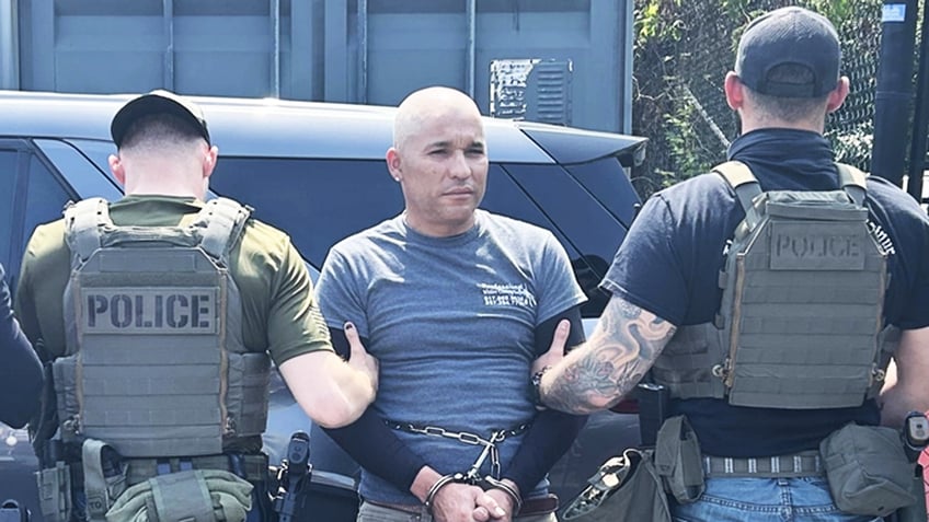 Emelio Neftaly Pineda handcuffed and being escorted by two ICE agents