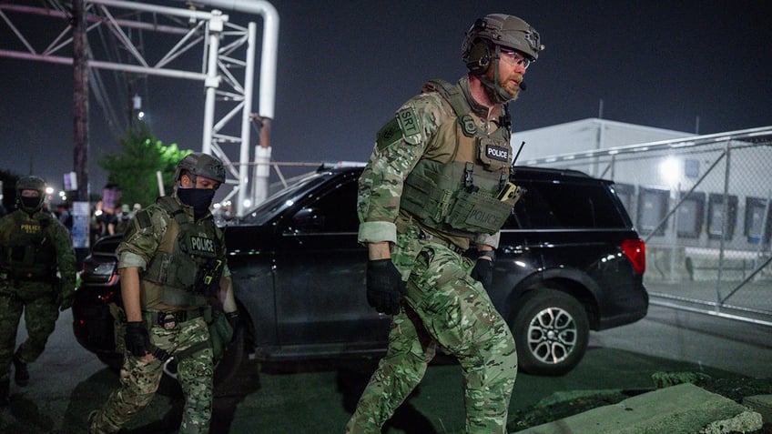 ICE agents in camo tactical gear 