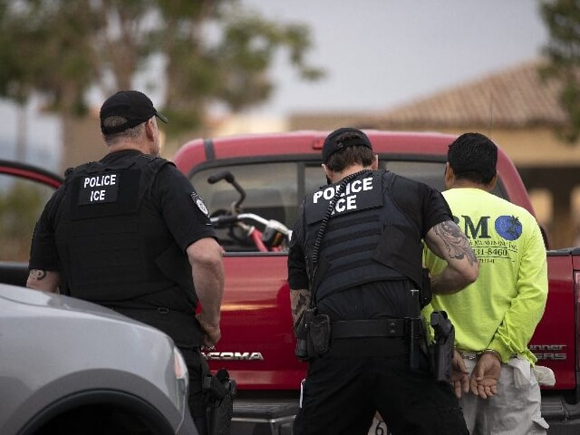 In this July 8, 2019, photo, a U.S. Immigration and Customs Enforcement (ICE) officers det